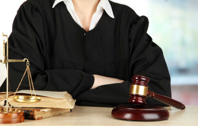 Judge,Sitting,At,Table,During,Court,Hearings,On,Room,Background