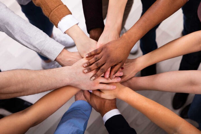 High,Angle,View,Of,Multiracial,Friend,Stacking,Hand,Together