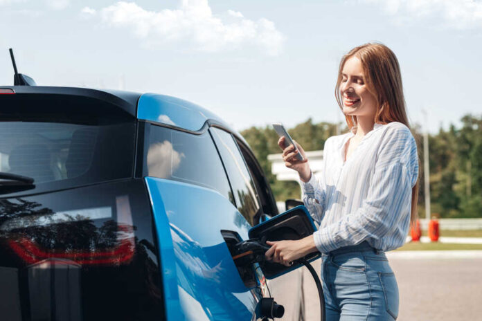 Young,Beautiful,Woman,Traveling,By,Electric,Car,Having,Stop,At