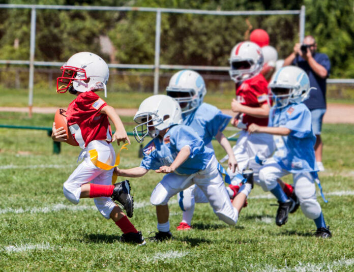 Unidentifiable,Kids,Playing,American,Flag,Football