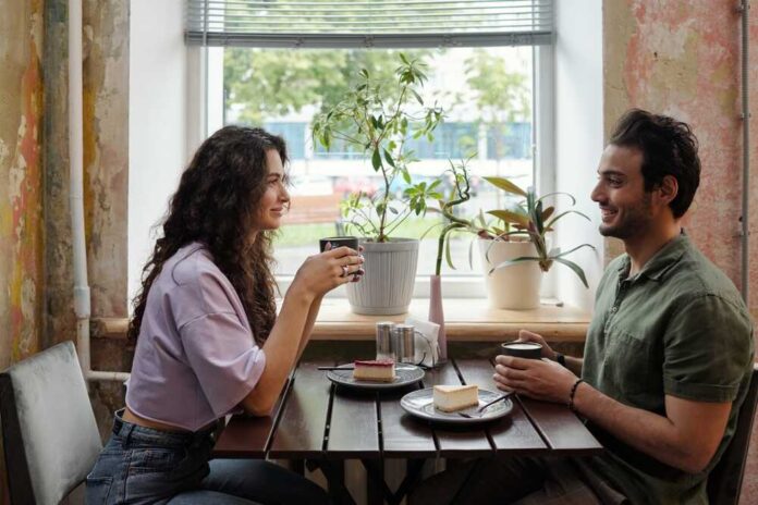 Young,Woman,And,Her,Smiling,Boyfriend,With,Cups,Of,Coffee