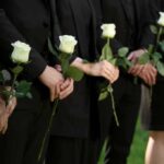 Fall City Washington Shooting: Teen Suspect Arrested After Five Found Dead in Home People in black holding white roses in a line.