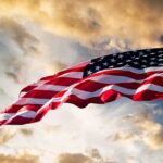 U.S. Increases Military Aid to Ukraine with $800 Million for Long-Range Drone Production American flag waving against a cloudy sky.