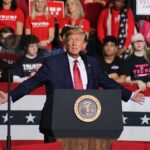 Rudy Giuliani Faces Defamation Claims and Legal Sanctions from Georgia Election Workers Politician speaking at rally with supporters behind him.