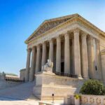 Huntington Beach Advances Voter ID Law After California Supreme Court Dismisses Lawsuit Stone building with columns and statues, clear blue sky.