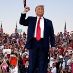 Person standing in front of cheering crowd.