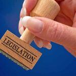 Hand holding a LEGISLATION stamp.