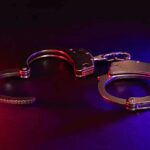 Handcuffs with red and blue dramatic lighting.