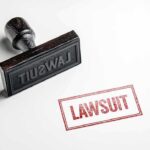Stamp labeled lawsuit on white surface
