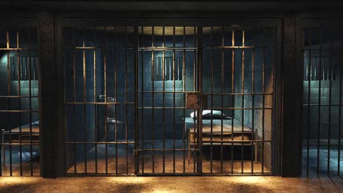 1427252378 featured image Empty prison cell with metal bars and bed.