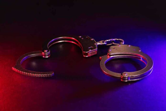 2423548283 featured image Handcuffs with red and blue dramatic lighting.