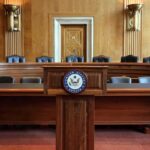Empty U.S. Senate hearing room with wooden furniture.
