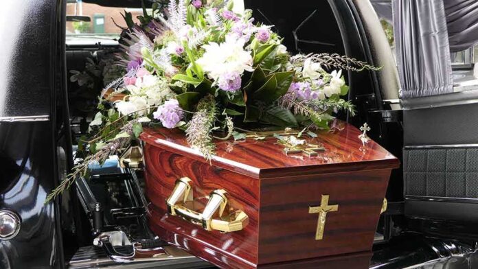 1785607928 featured image Coffin with flower arrangement in a hearse.