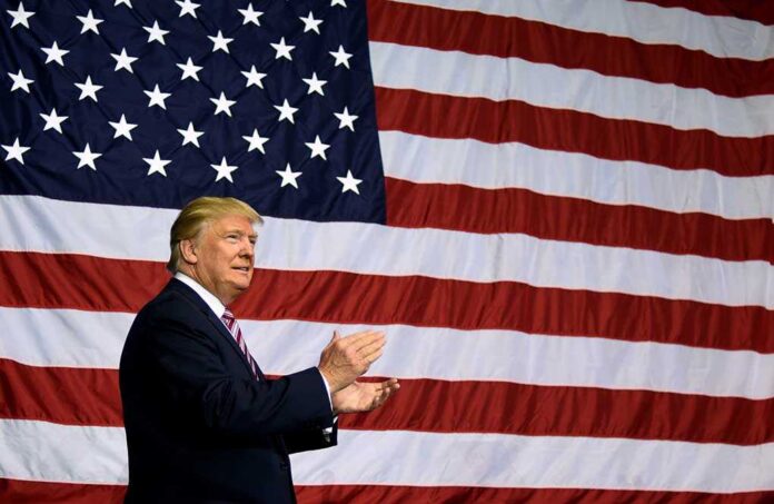 1848623440 featured image Man clapping in front of American flag backdrop