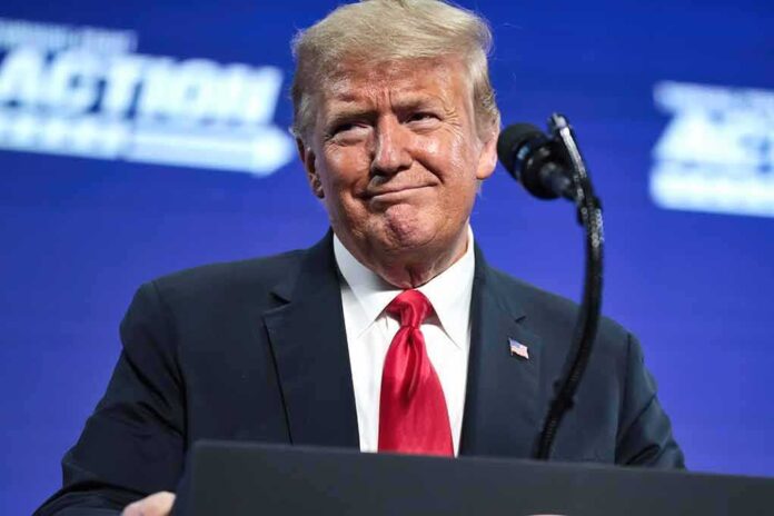 2475617573 featured image Man in suit and red tie at podium.