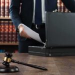 Gavel and person opening briefcase in law office