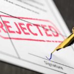 Rejected stamp on a document with pen.