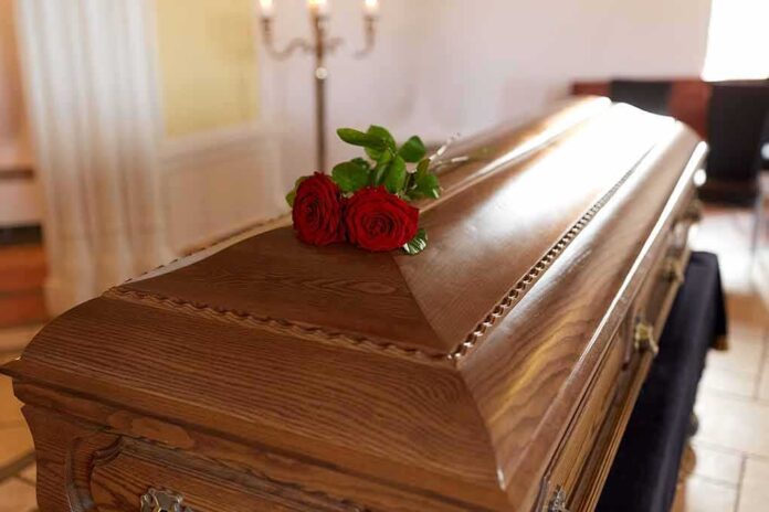 664198003 featured image Wooden casket with red roses on top.