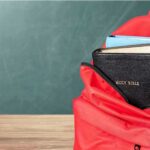 Red backpack with a Bible and books inside