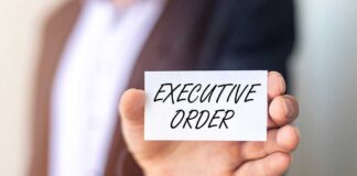 Man holding card saying executive order