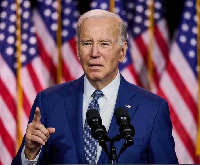 2307248525 featured image Man speaking at podium with American flags behind.