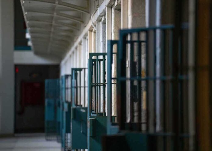 2322796263 featured image Prison cell block corridor with gated doors.