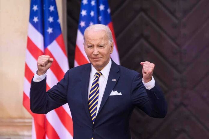 2330820239 featured image Man in suit raising fists American flags behind him