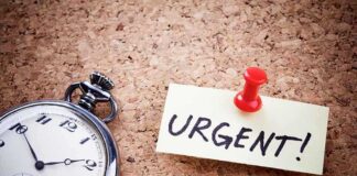 Pocket watch and urgent note pinned on corkboard