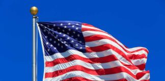 American flag waving against clear blue sky