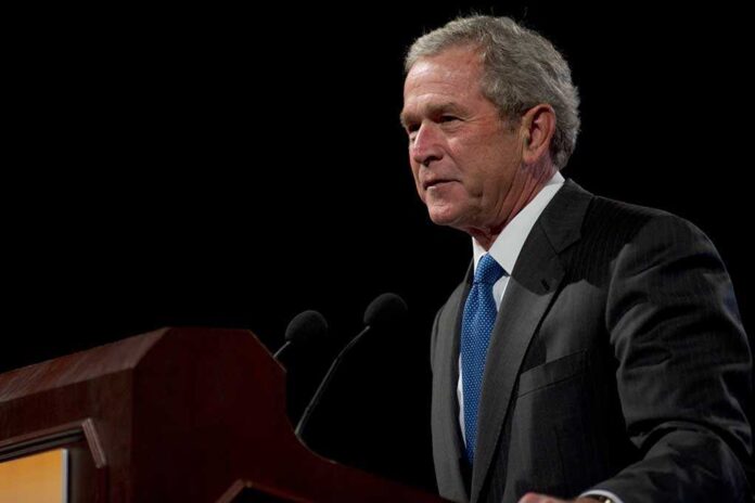 73343557 featured image A man speaking at a podium in a dark room.