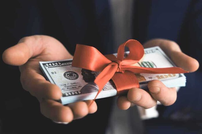 1690384846 featured image Hands holding stack of hundred dollar bills with ribbon