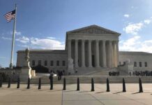 Supreme Court building with flag and people outside