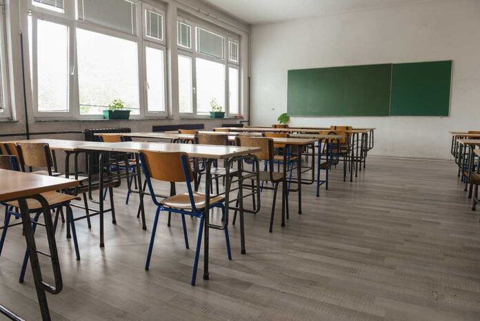 487861393 featured image Empty classroom with desks chairs windows and chalkboard