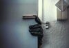 Gloved hand opening door with security chain