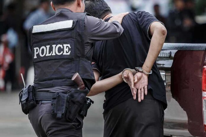 693957643 featured image Police officer arrests handcuffed person