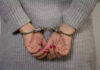 Person in handcuffs with gray sweater