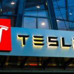 Tesla logo on a building at night.