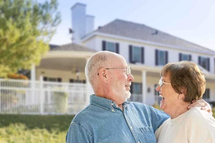 Elderly couple smiling and enjoying each other's company in front of a house