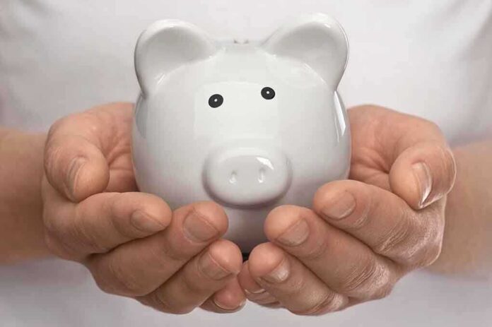 Hands holding a white ceramic piggy bank