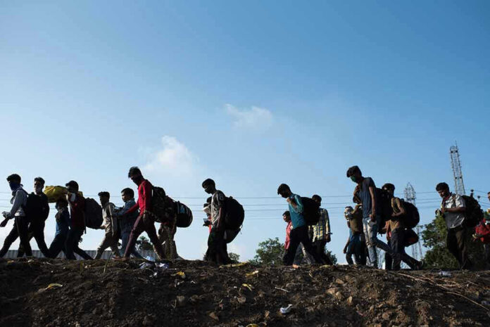 Line of people walking with backpacks outdoors