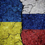 Cracked Ukrainian and Russian flags painted on concrete