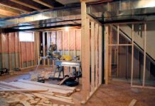 SNEAKY Renovation Trap Costs Homeowners Thousands Interior of a basement under construction with wooden frames and tools