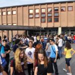 A large group of students socializing outside a school building