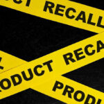 Yellow tape with product recall text on black background