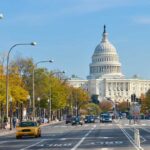 View of the Capitol building in Washington DC with autumn trees lining the street