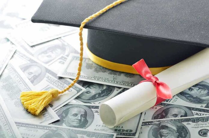 Graduation cap and diploma resting on a pile of money