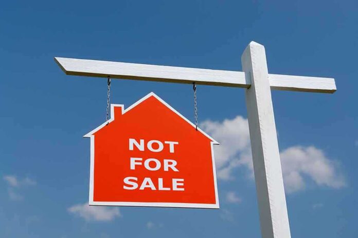 Red Not For Sale sign hanging from a white post against a blue sky