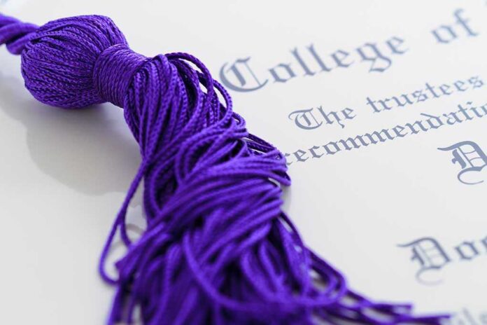 Close up of a purple graduation tassel next to a diploma