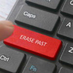 Finger pressing ERASE PAST key on keyboard.