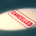 Red Cancelled stamp under a spotlight.